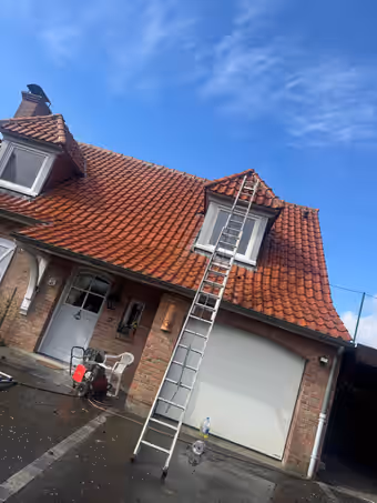 La même maison en brique après le nettoyage, tuiles rouges propres, échelle contre la façade