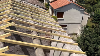Liteaux et chevrons neufs posés au-dessus d’une ancienne couverture en tuiles