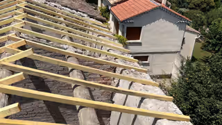 Liteaux et chevrons neufs posés au-dessus d’une ancienne couverture en tuiles